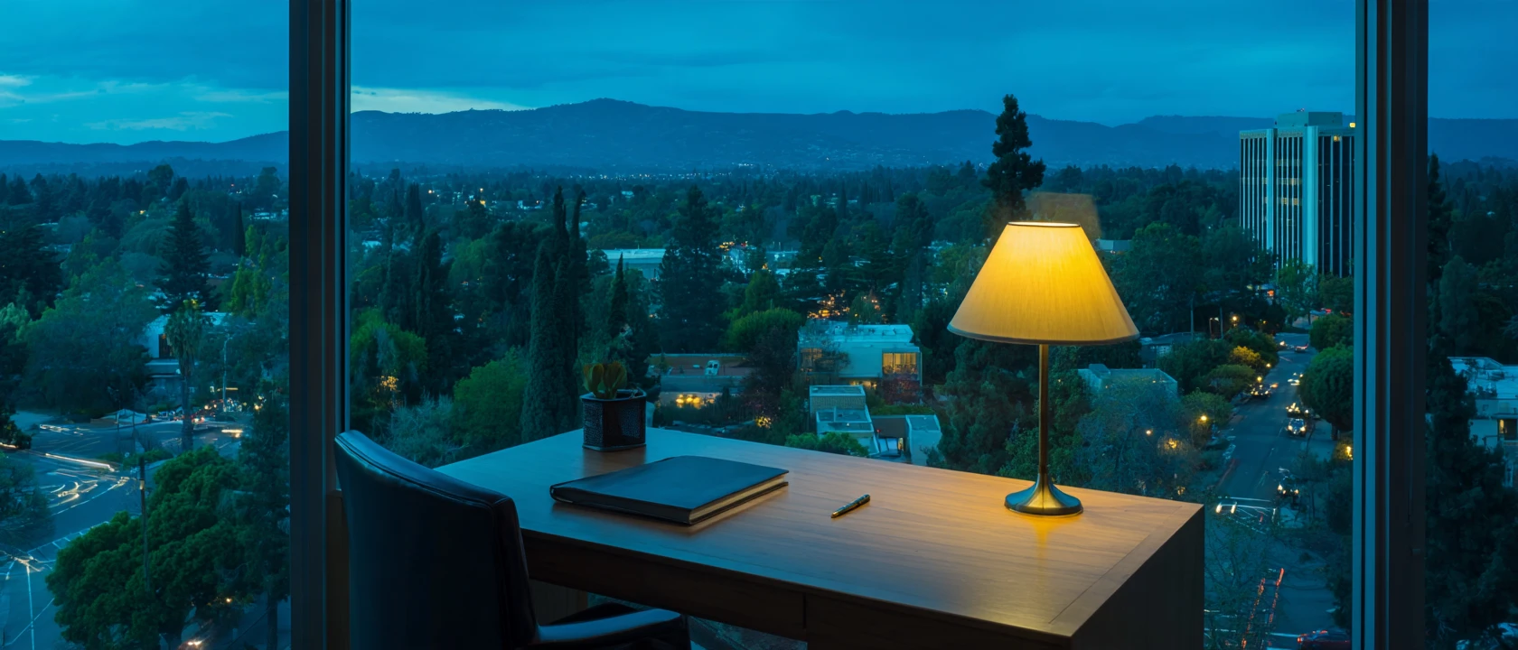 Illustrative desk by a window overlooking Silicon Valley at dusk; not a Hickok office or client.
